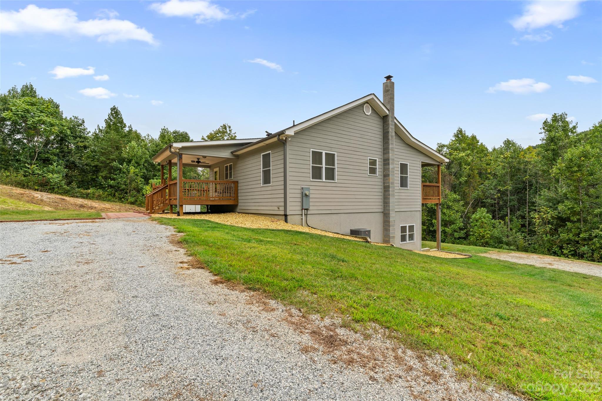 6363 Cheatham Ford Road Hiddenite, NC 28636 - Photo 30 of 32 a view of a house with a yard and large tree