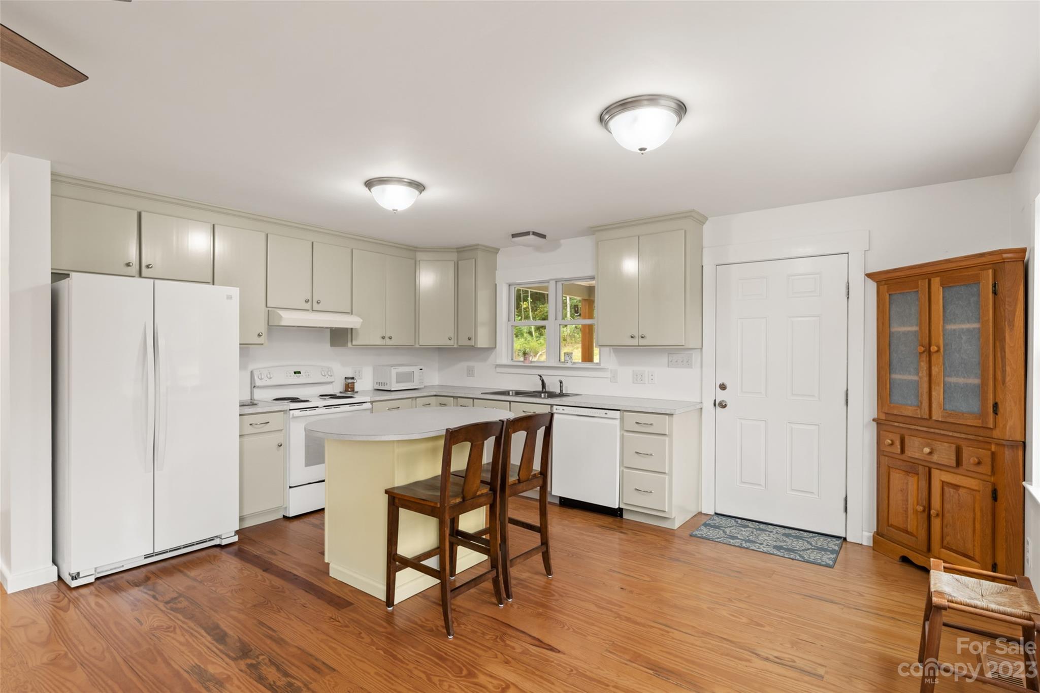 6363 Cheatham Ford Road Hiddenite, NC 28636 - Photo 4 of 32 a kitchen with white cabinets and white appliances