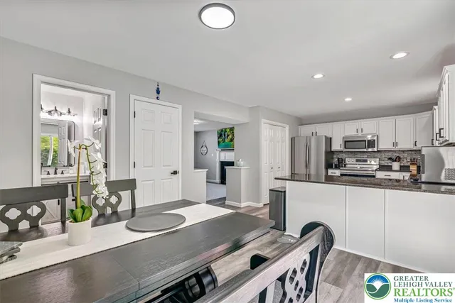 a kitchen with cabinets stainless steel appliances and wooden floor