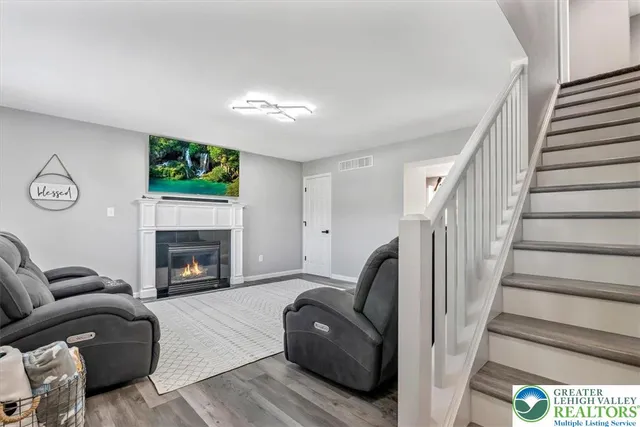 a living room with a fireplace windows and a wooden floor