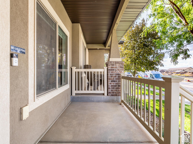 40 Ginger Gold Road Santaquin, UT 84655 - Photo 24 of 32 Covered front porch featuring a concrete floor, stucco exterior, and white railing