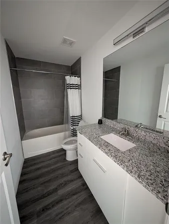 a bathroom with a granite countertop sink toilet and shower