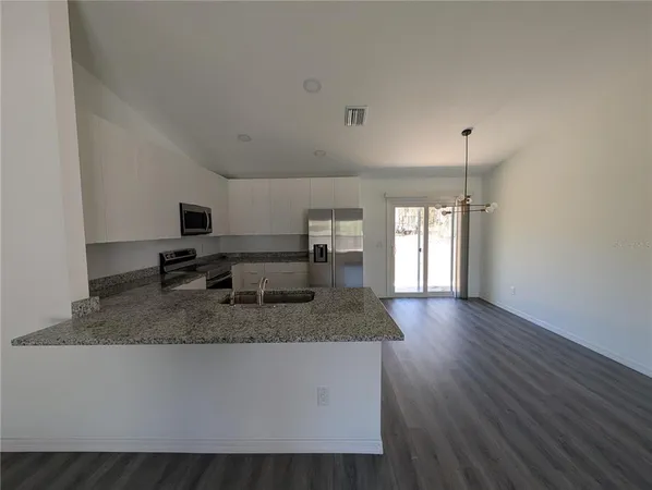 a kitchen with kitchen island granite countertop a sink window and refrigerator