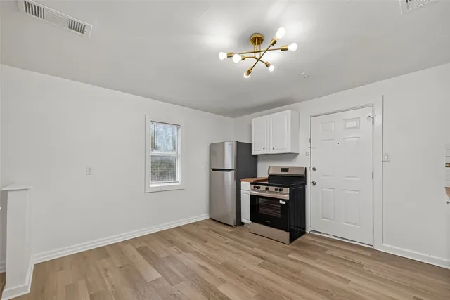 a kitchen with a refrigerator and a stove top oven