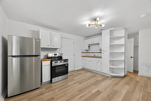 a white refrigerator freezer and a stove sitting inside of a kitchen