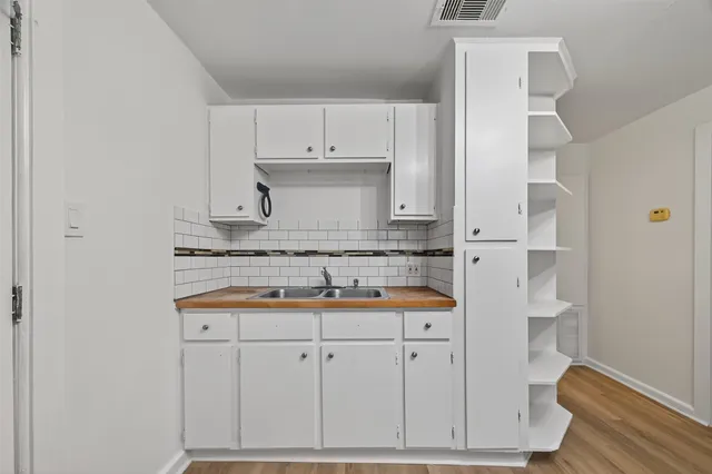 a view of a room with wooden floor and a ceiling fan