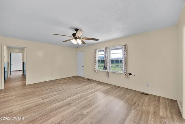 a view of a livingroom with wooden floor and a ceiling fan