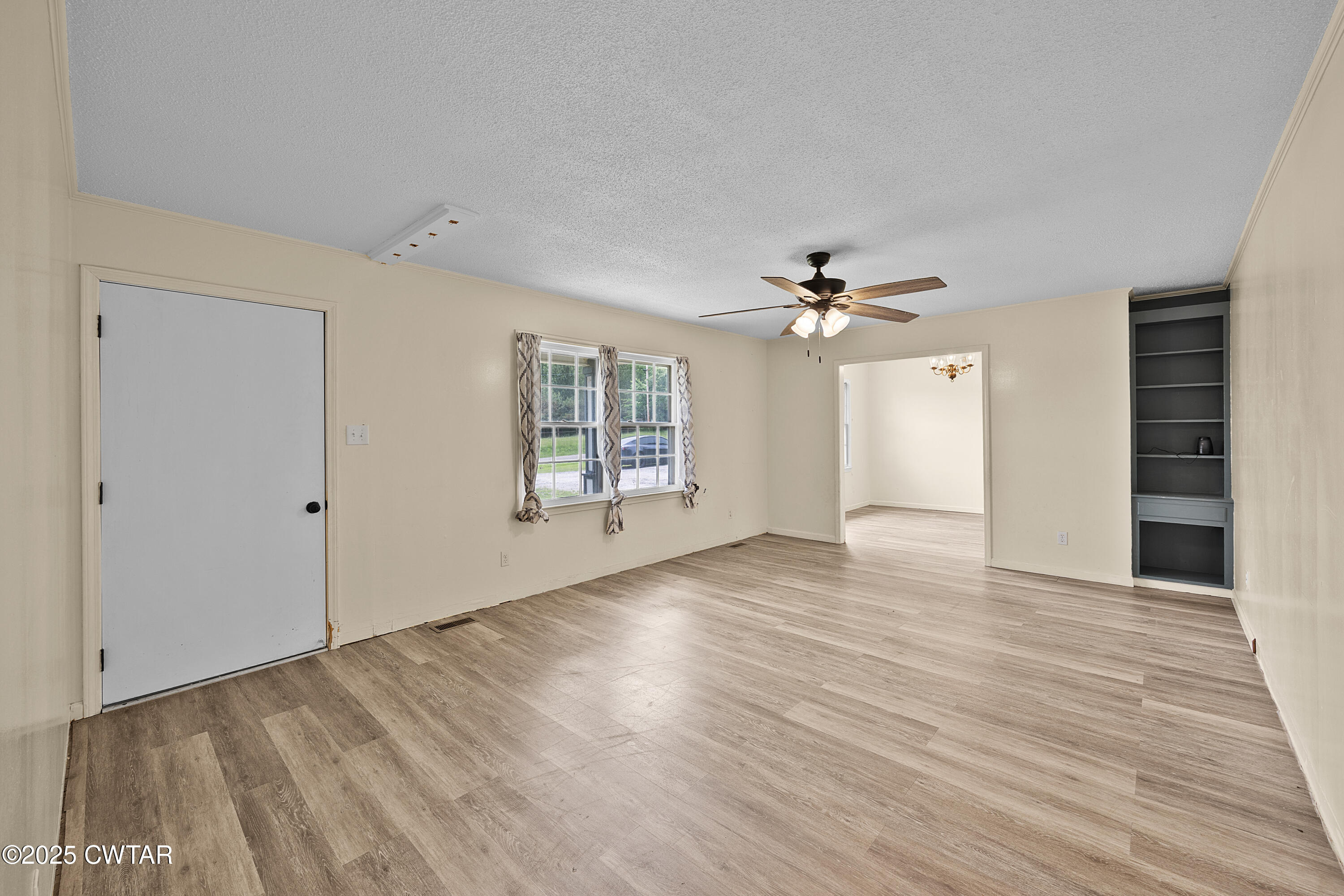 5790 Smyrna Road Westport, TN 38387 - Photo 15 of 26 a view of a livingroom with wooden floor and a ceiling fan