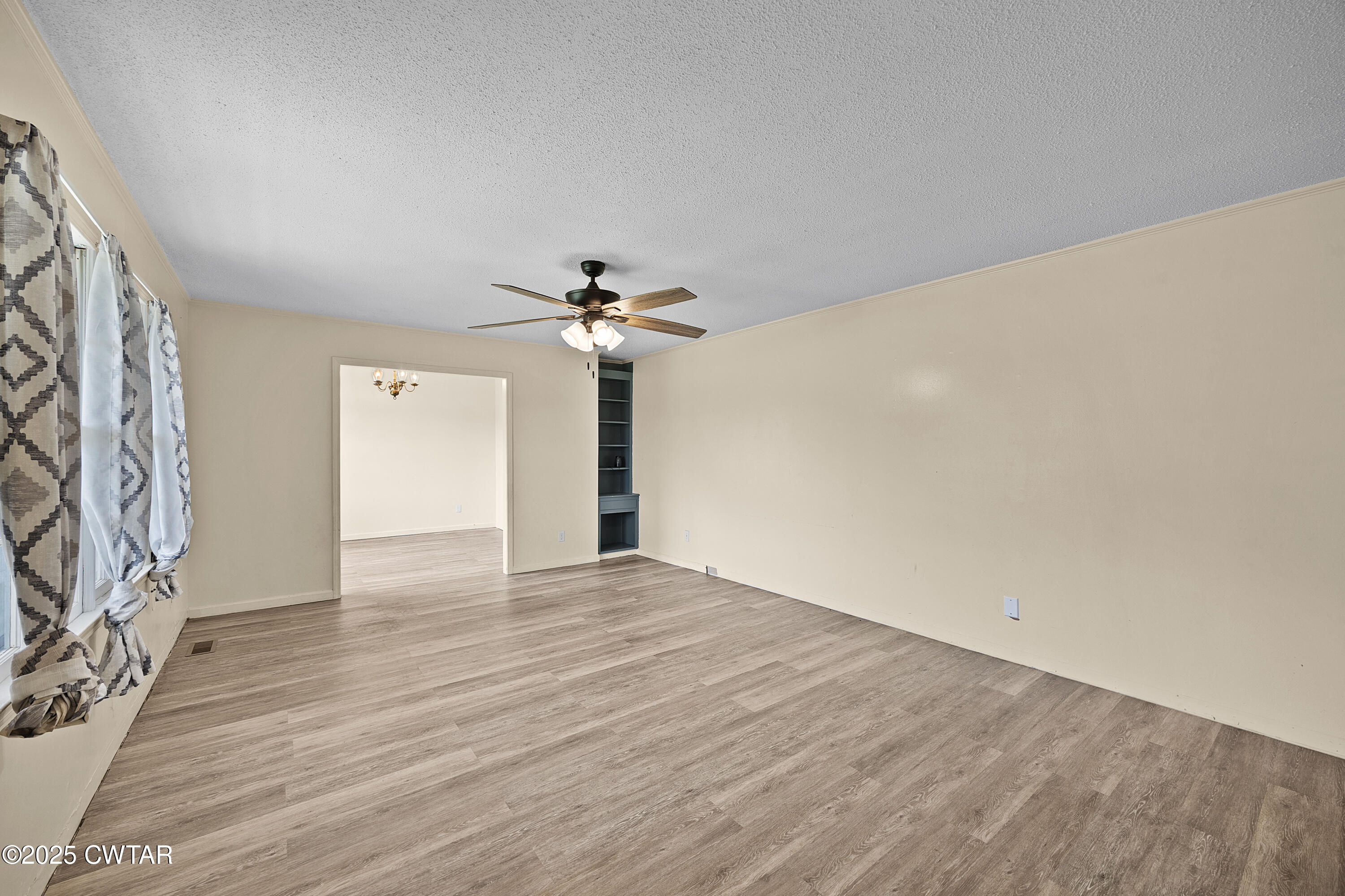 5790 Smyrna Road Westport, TN 38387 - Photo 16 of 26 a view of an empty room with wooden floor and a ceiling fan