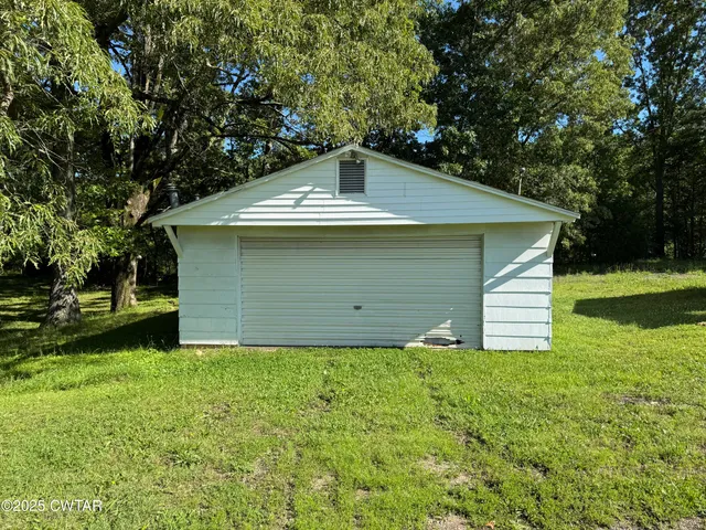 a view of a small house with backyard
