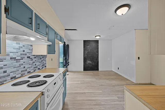 a large kitchen with a stove top oven and refrigerator
