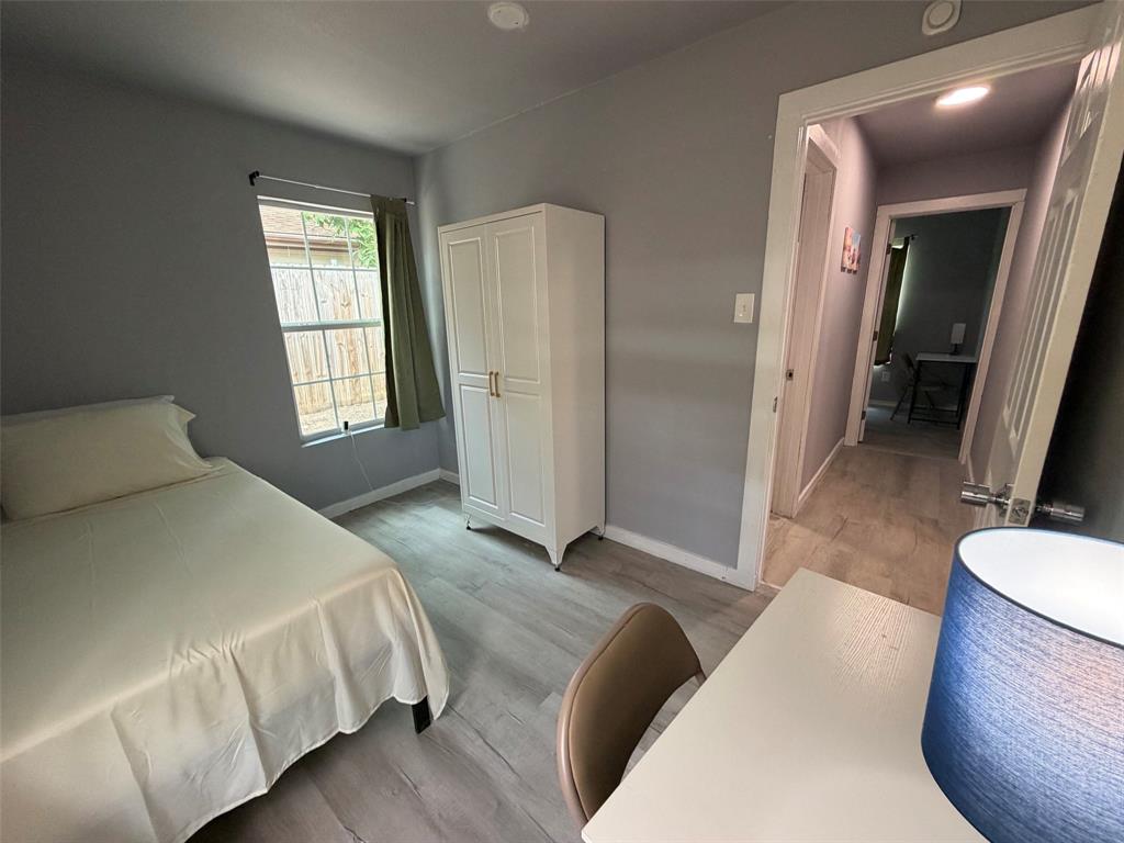 714 Southwest Dallas Street Grand Prairie, TX 75051 - Photo 12 of 27 Bedroom featuring light gray walls and wood-finish flooring