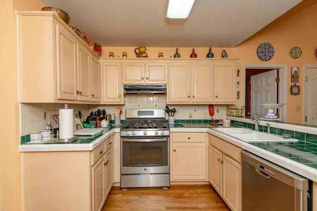 a kitchen with granite countertop white cabinets and white appliances