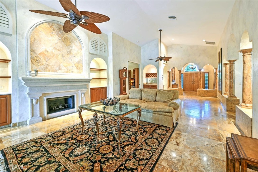 481 Crestwood Road Naples, FL 34113 - Photo 11 of 27 a living room with fireplace furniture and a chandelier