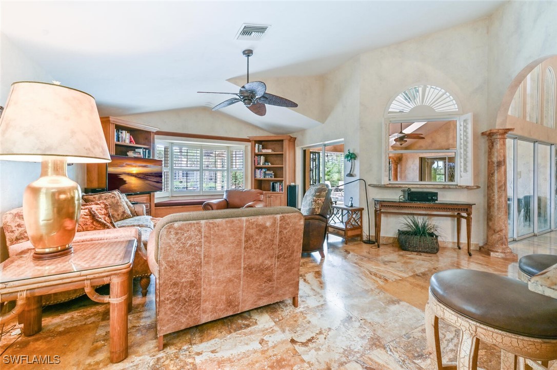 481 Crestwood Road Naples, FL 34113 - Photo 14 of 27 a living room with furniture a fireplace and a chandelier