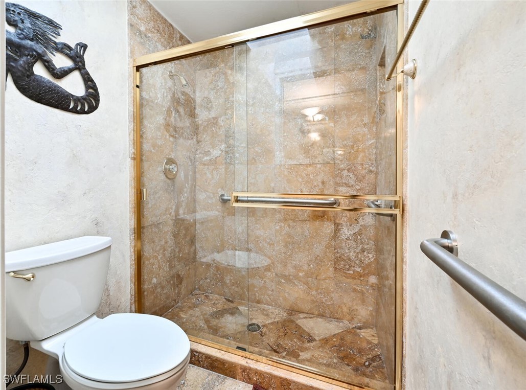 481 Crestwood Road Naples, FL 34113 - Photo 20 of 27 a white toilet sitting next to a bathroom sink