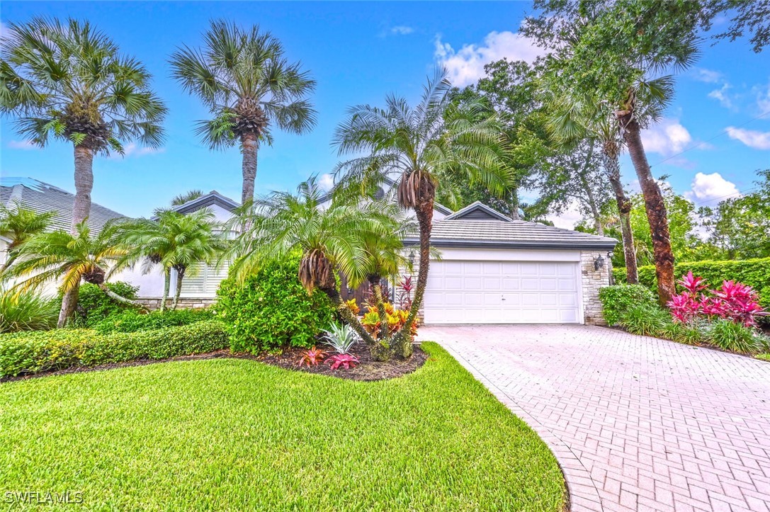 481 Crestwood Road Naples, FL 34113 - Photo 3 of 27 a front view of a house with a garden and tree