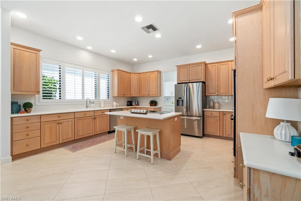 764 Ashburton Drive Naples, FL 34110 - Photo 11 of 30 a large kitchen with kitchen island a sink a counter top stainless steel appliances and cabinets