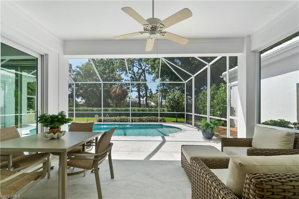 764 Ashburton Drive Naples, FL 34110 - Photo 14 of 30 a view of a livingroom and dining room with furniture and large windows
