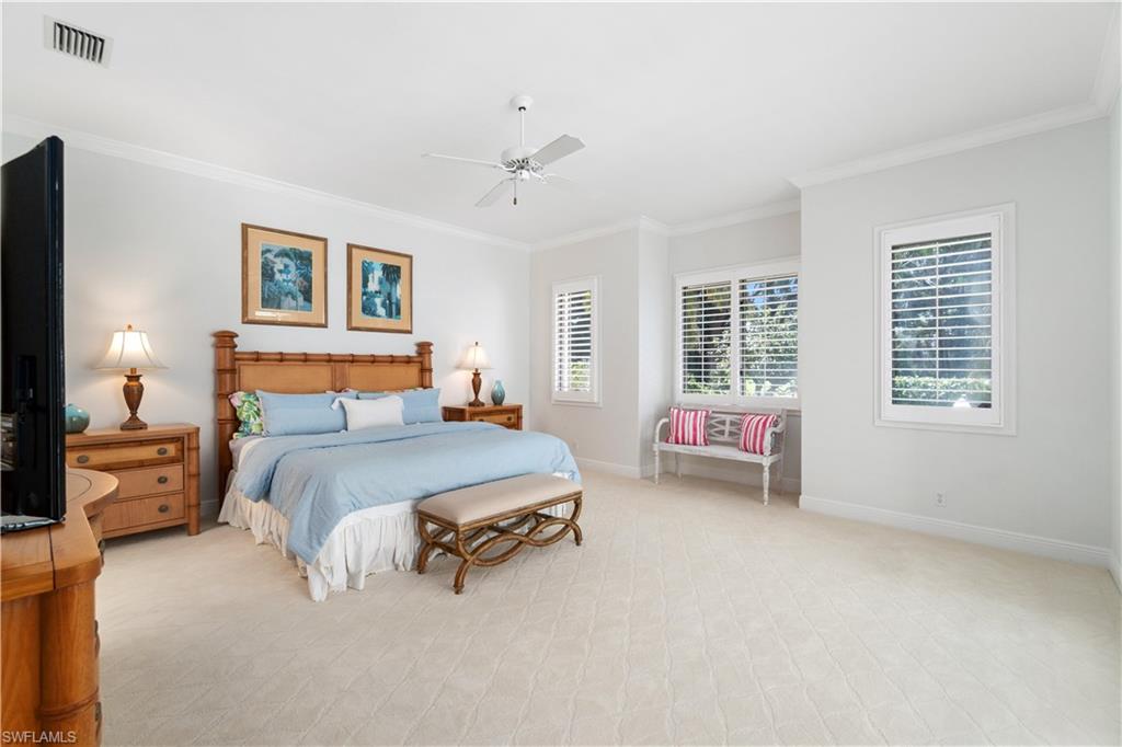764 Ashburton Drive Naples, FL 34110 - Photo 19 of 30 a spacious bedroom with a bed and a couch