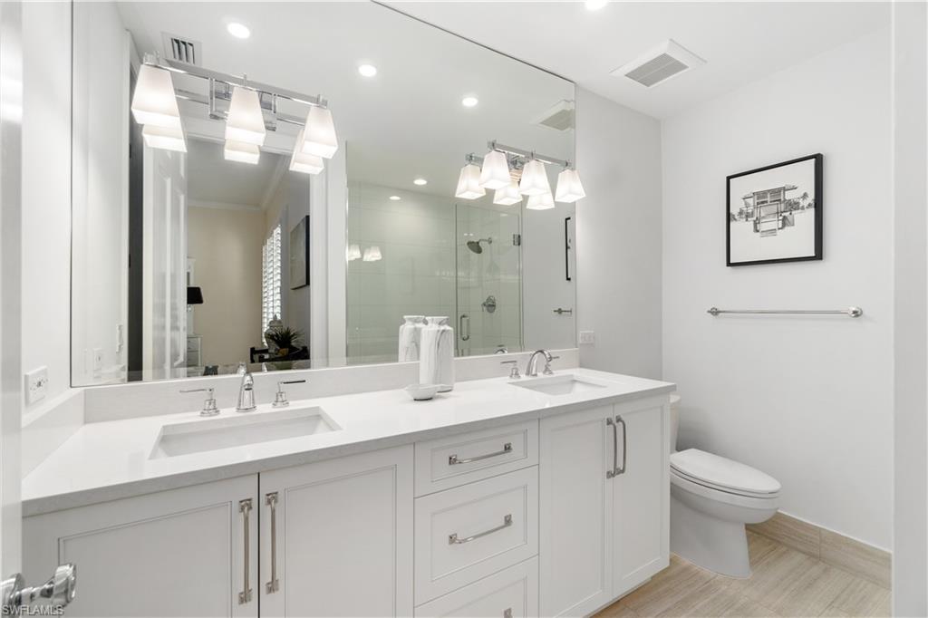 764 Ashburton Drive Naples, FL 34110 - Photo 27 of 30 a bathroom with a toilet a sink a mirror and vanity