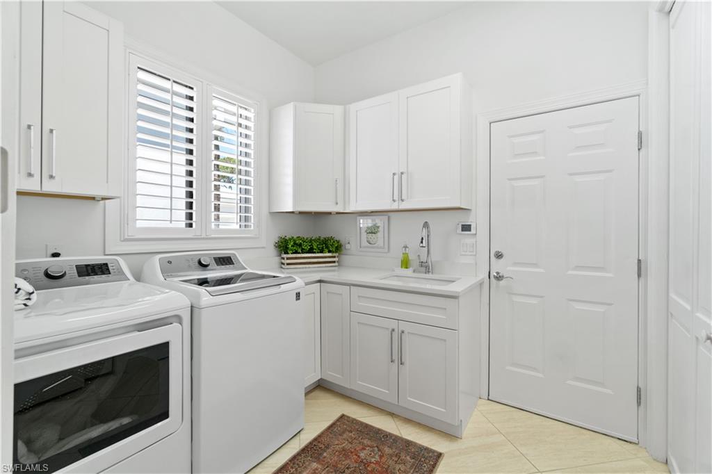 764 Ashburton Drive Naples, FL 34110 - Photo 29 of 30 a utility room with cabinets washer and dryer