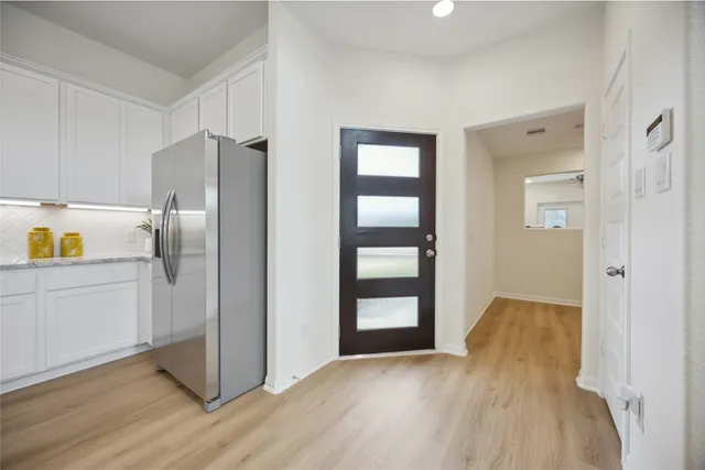 a view of kitchen with a refrigerator cabinets and wooden floor
