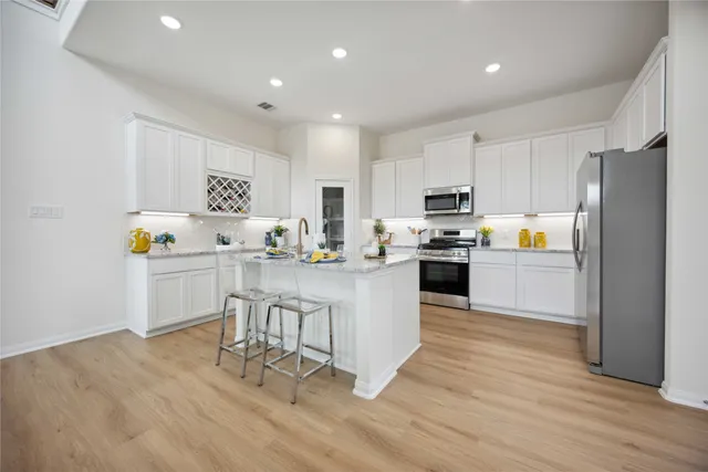 a kitchen with white cabinets and stainless steel appliances