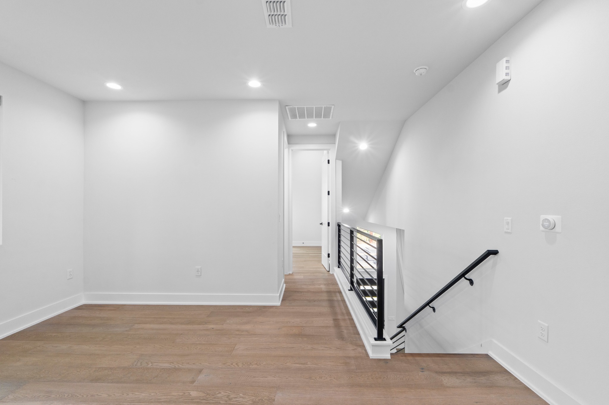 2007 Chestnut Avenue, Unit 1 Austin, TX 78722 - Photo 17 of 32 Blonde hardwood flooring connects this luminous loft space to the hallway and stairwell.
