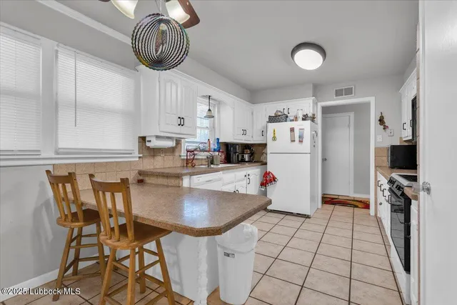 a kitchen with a table chairs refrigerator and cabinets