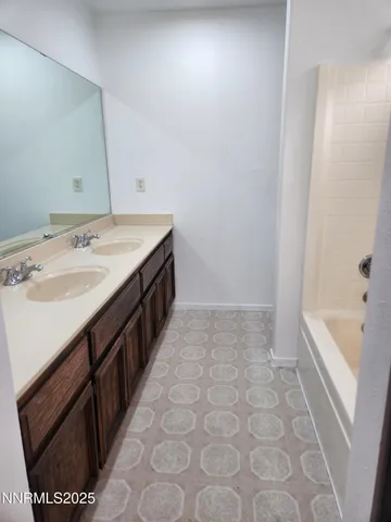 a spacious bathroom with a tub sink and mirror