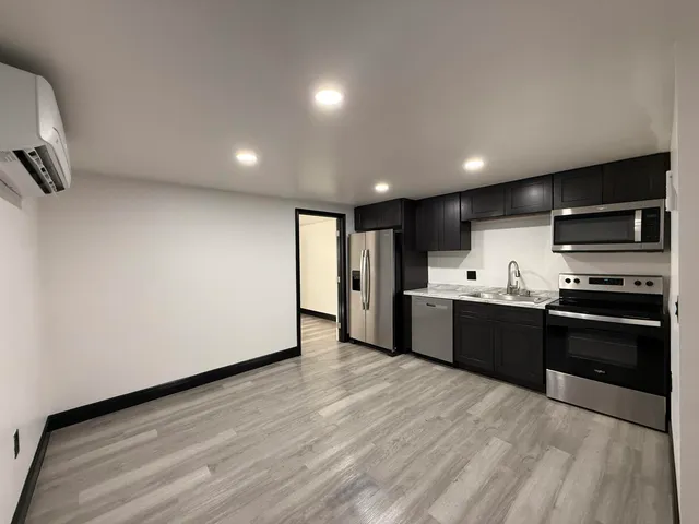 a large kitchen with stainless steel appliances kitchen island a large counter top and a stove top oven