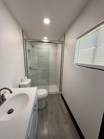 a bathroom with a sink a toilet and shower