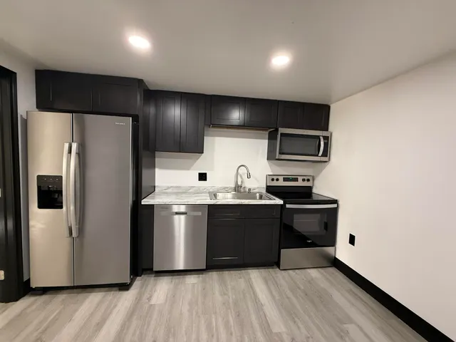 a kitchen with stainless steel appliances a refrigerator and a stove top oven