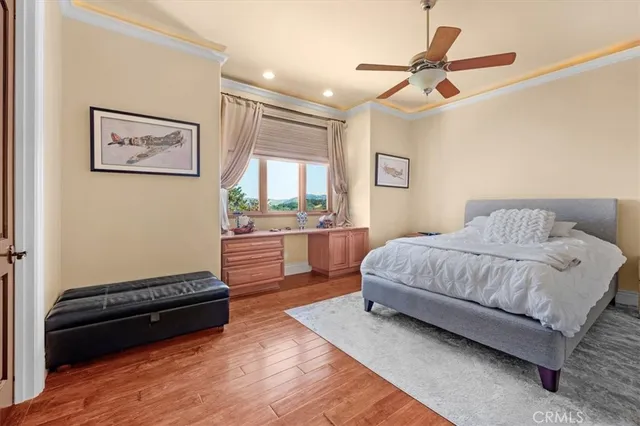 a spacious bedroom with a bed a chandelier and dresser