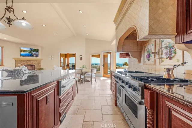 a kitchen with stainless steel appliances granite countertop a refrigerator a sink and a stove