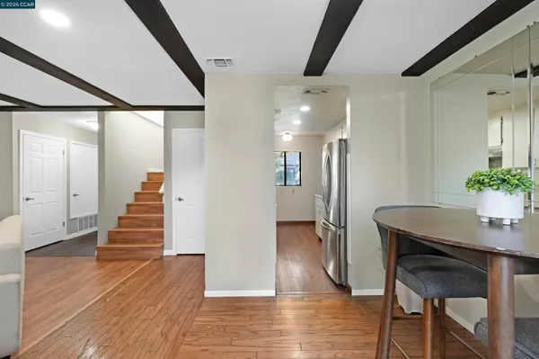 a view of a hallway with wooden floor and staircase