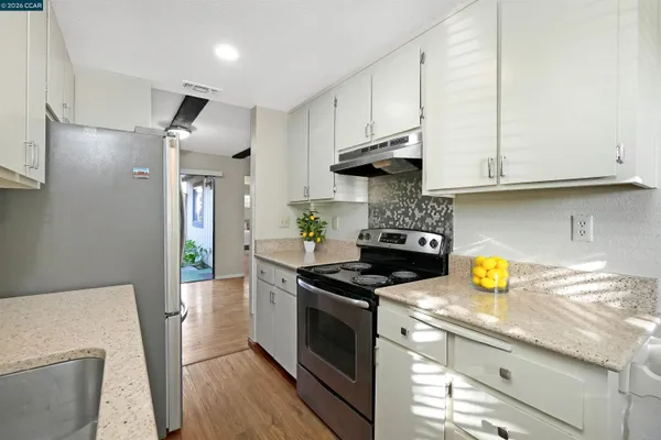 a kitchen with stainless steel appliances granite countertop a stove a sink and a refrigerator