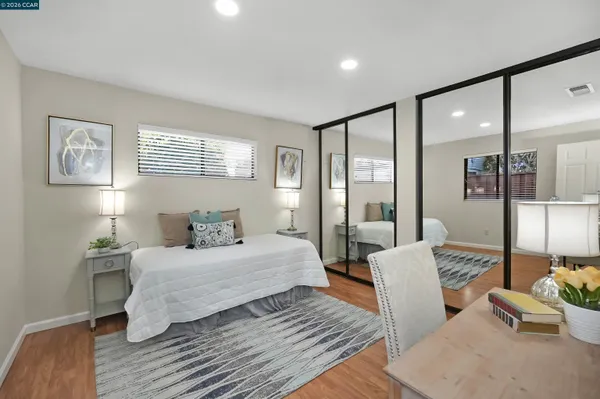a bedroom with a large bed and wooden floor