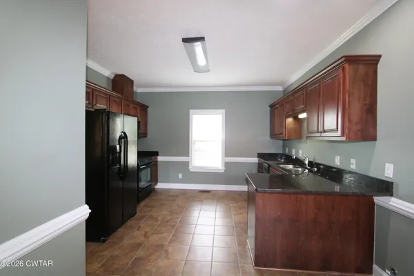 a kitchen with granite countertop a refrigerator and a stove top oven