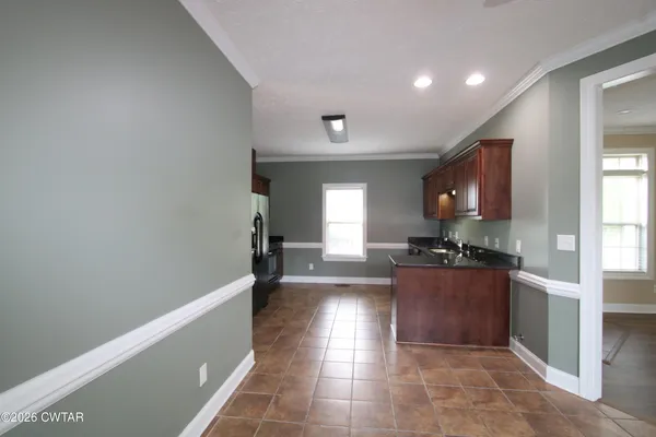 a kitchen with granite countertop a stove a sink and a refrigerator