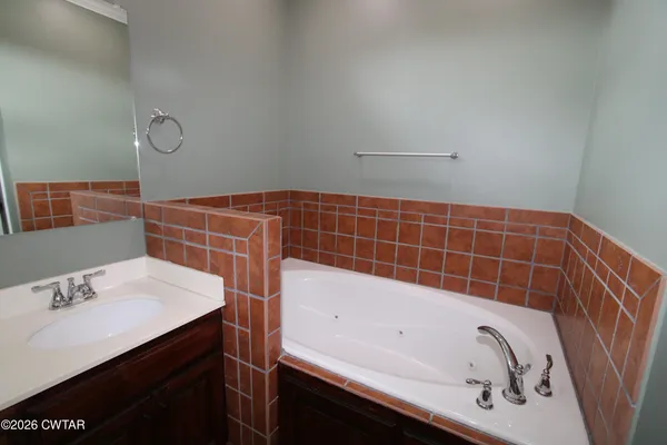 a bathroom with a bathtub sink and mirror