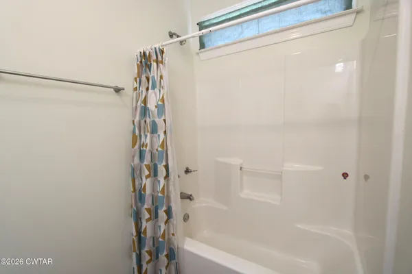 a white toilet sitting next to a shower curtain