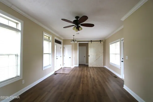 a view of a livingroom with a window and wooden floor