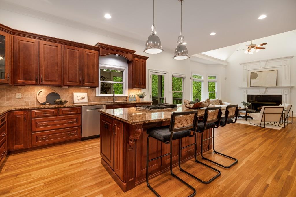 8345 Jett Ferry Road Sandy Springs, GA 30350 - Photo 22 of 61 a kitchen with granite countertop a stove a sink dishwasher and a dining table with cabinets
