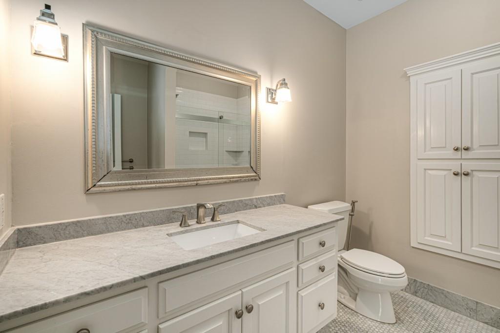 8345 Jett Ferry Road Sandy Springs, GA 30350 - Photo 35 of 61 a bathroom with a granite countertop sink a toilet and a mirror