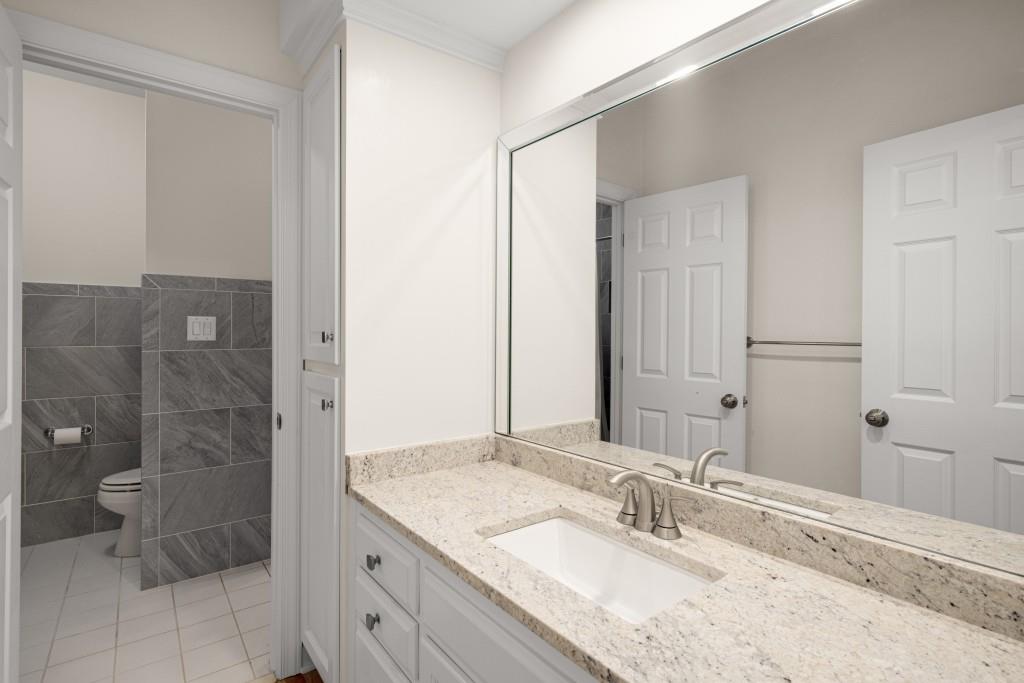 8345 Jett Ferry Road Sandy Springs, GA 30350 - Photo 38 of 61 a bathroom with a granite countertop sink a mirror and a shower