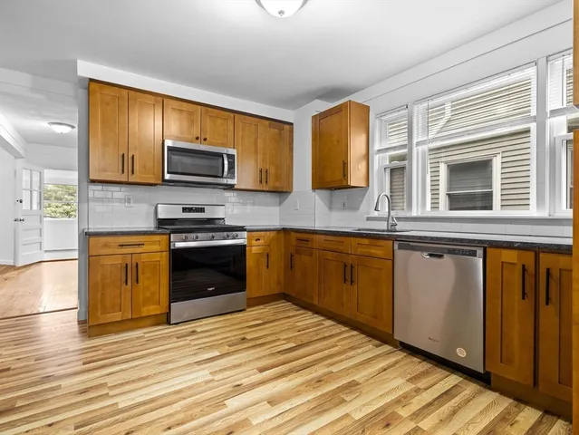 a kitchen with stainless steel appliances granite countertop a stove a sink and a microwave