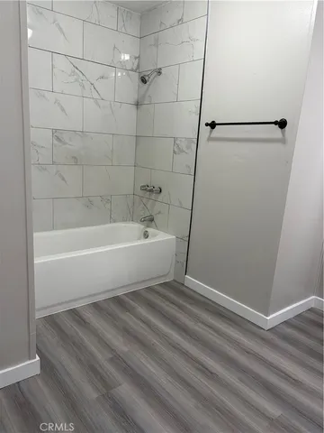 a white bath tub sitting next to a shower