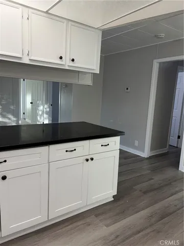 a kitchen with granite countertop white cabinets and a sink